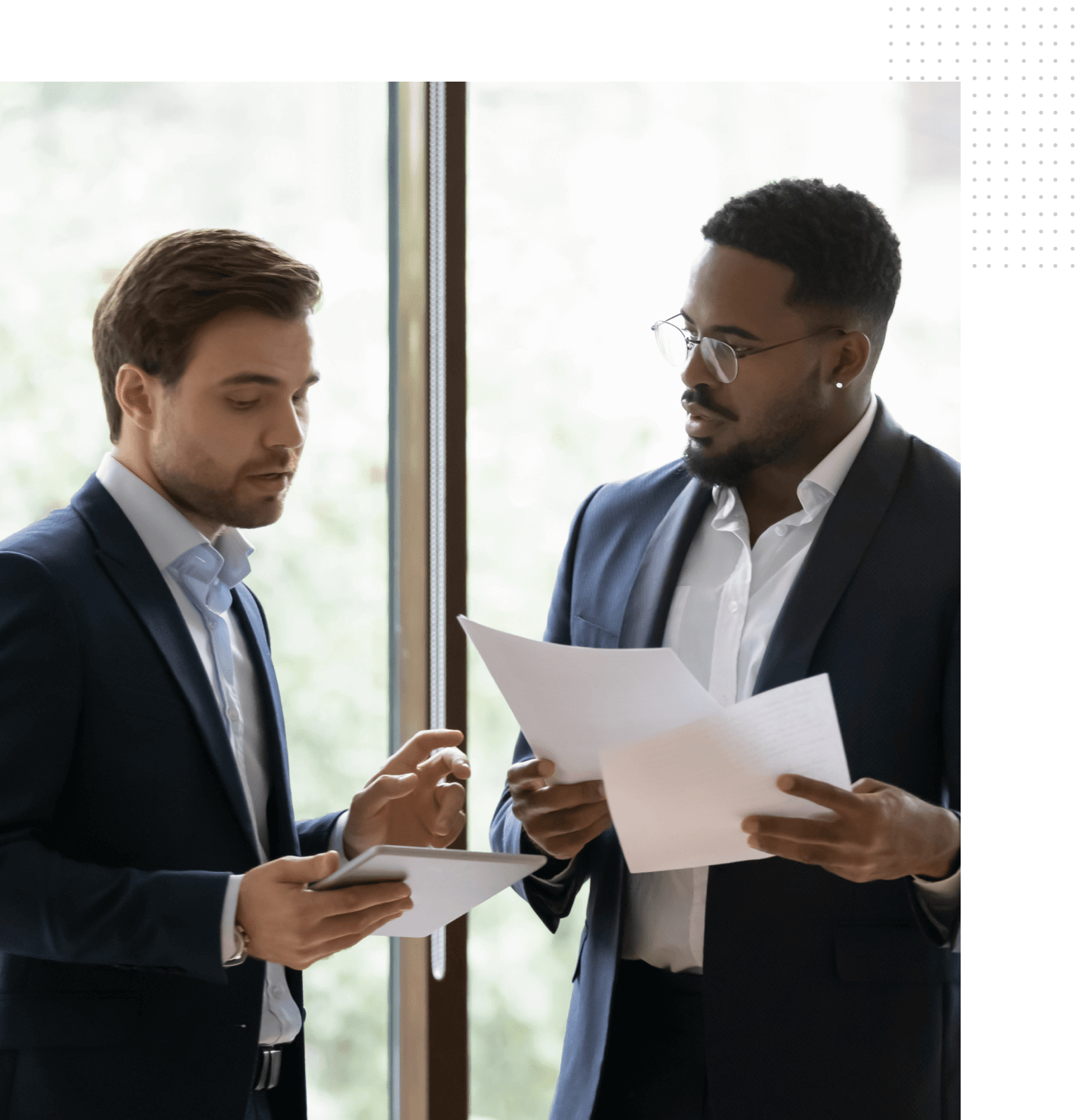 Two men in suits looking at papers